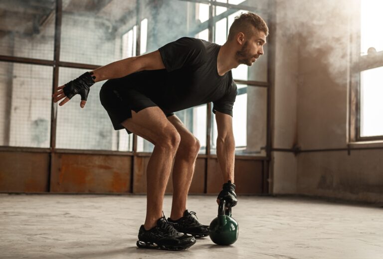 Sportsman working out with kettlebell in gym
